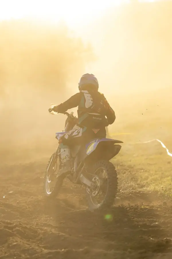 Una moto da fuoristrada di spalle nella polvere controluce