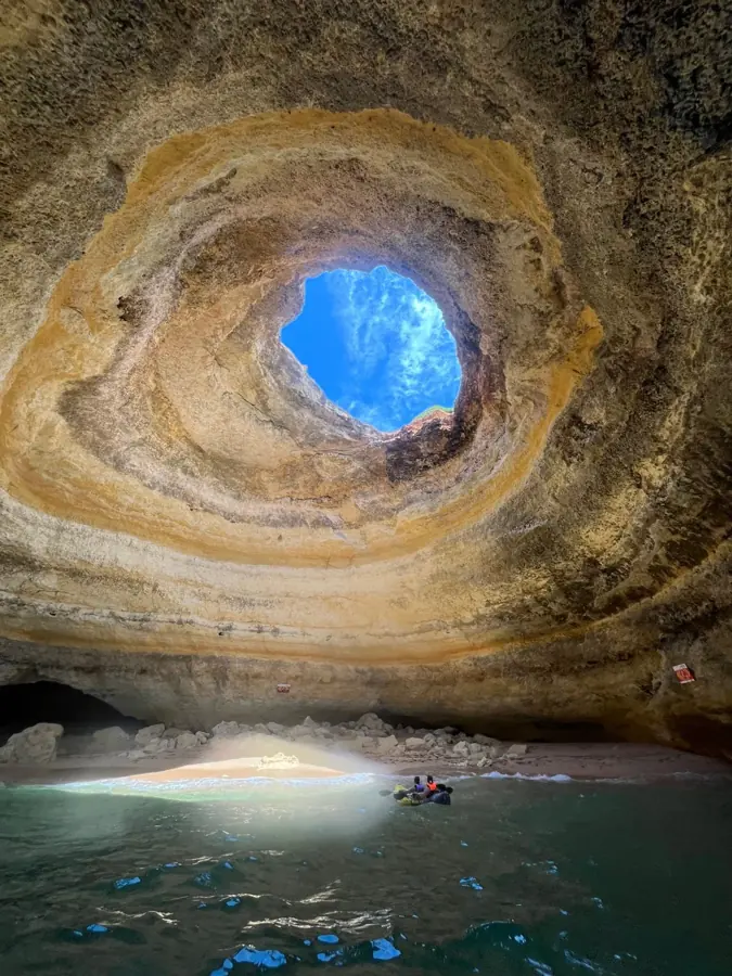 L'interno della grotta di Benagil con l'apertura nel soffitto e un kayak sulla riva