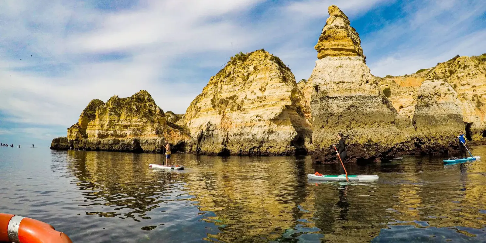 Tavole da paddle sull'acqua liscia tra i faraglioni dorati dell'Algarve