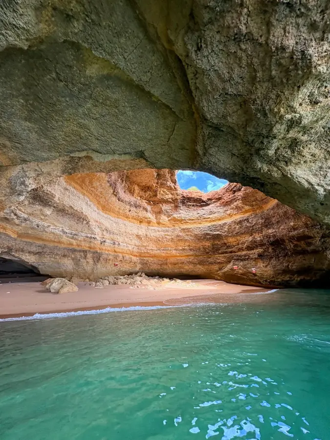 La volta dorata della grotta di Benagil sopra l'acqua turchese