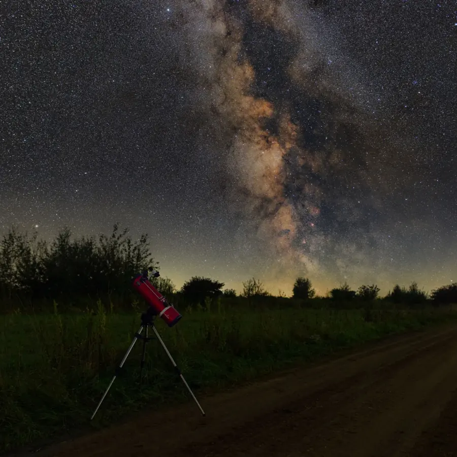 Un piccolo telescopio su una strada di campagna sotto la Via Lattea