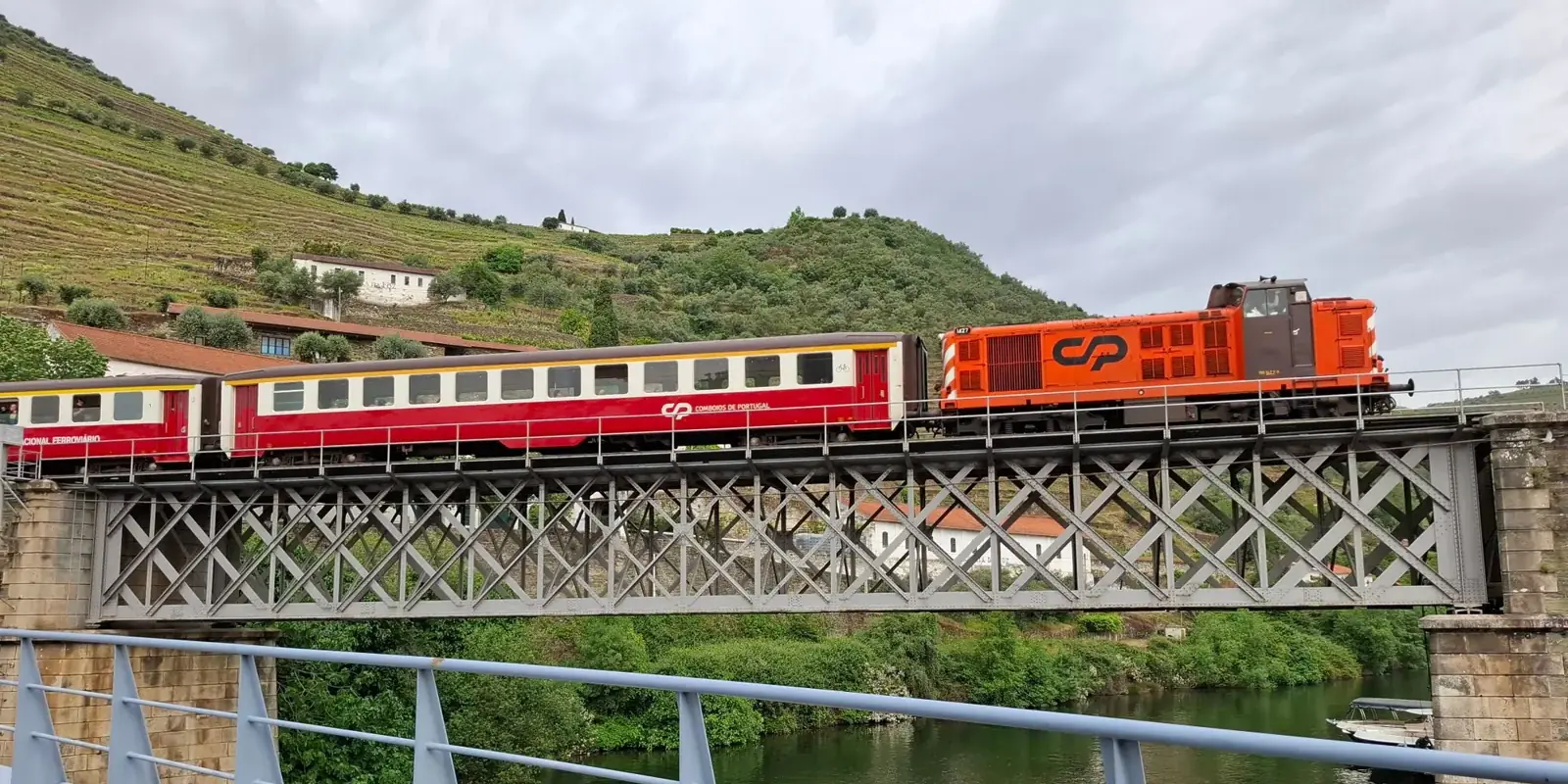 Un treno attraversa il ponte in ferro sul fiume nella valle del Douro