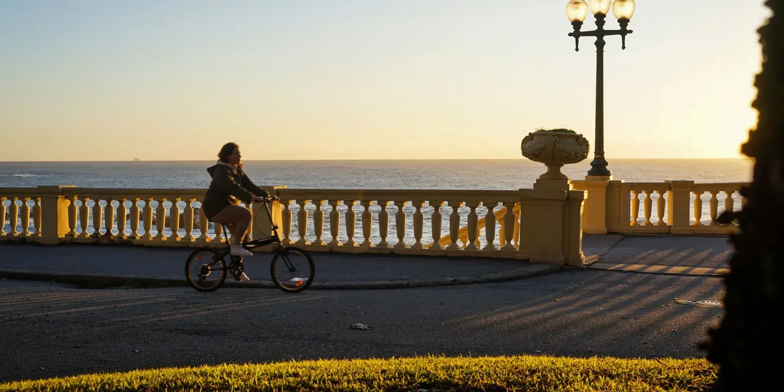 Un ciclista sul lungomare affacciato sull'Atlantico al tramonto