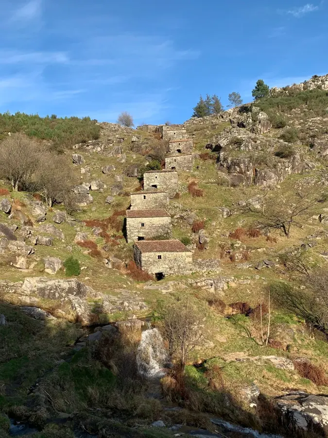 Antichi mulini ad acqua in pietra in fila sul pendio di una collina